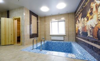 a large indoor pool with blue mosaic tiles , surrounded by white walls and a window at Vernisage