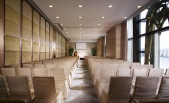 A spacious room with rows of chairs in the center, accompanied by an empty conference table at Harbour Grand Hong Kong