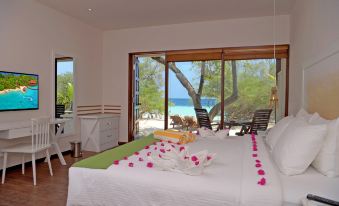 a bedroom with a large bed and a view of the ocean through a window at Eriyadu Island Resort