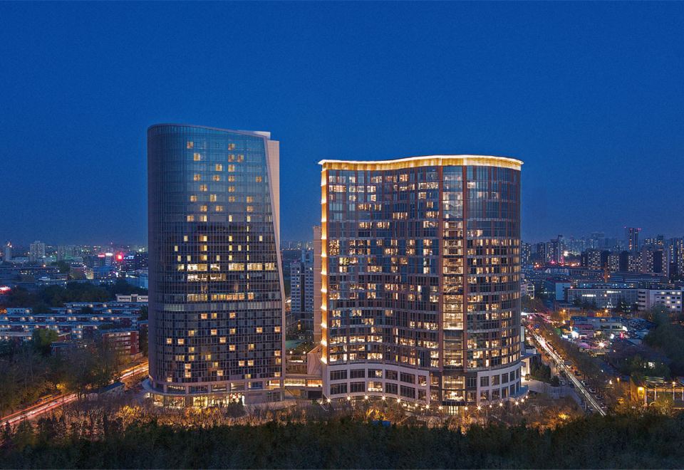 At night, a cityscape is illuminated by blue and white lights atop the buildings at Nuo Hotel Beijing