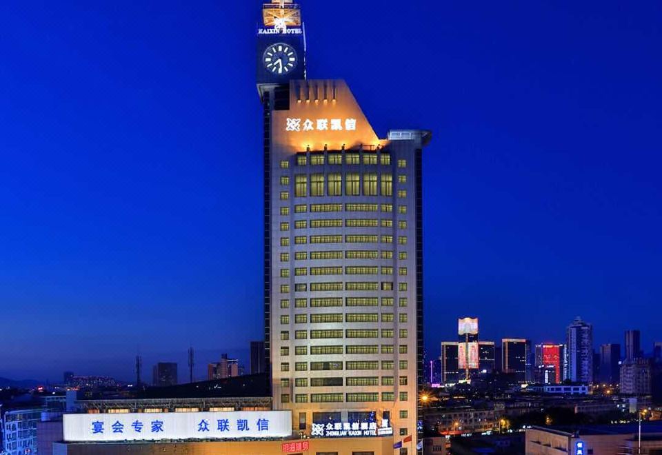 The city is illuminated at night with buildings glowing in blue and white lights at YiWu Zhonglian Kaixin Hotel