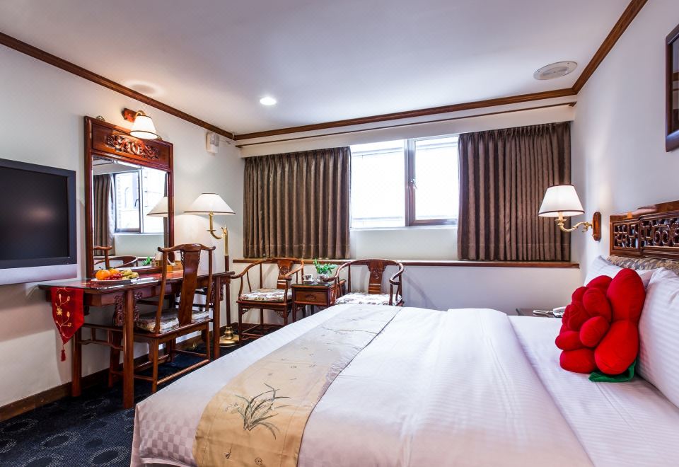 a well - lit hotel room with a comfortable bed , wooden furniture , and a window with curtains at Han She Business Hotel
