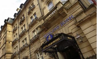 "a brick building with a sign that reads "" titanic hotel "" prominently displayed on the front" at The Midland Hotel