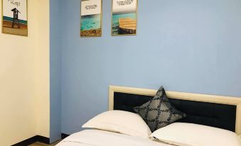a blue bedroom with a bed and two pictures hanging on the wall above the bed at Leisure