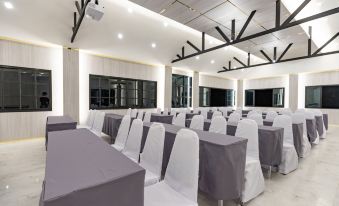 a large conference room with multiple rows of chairs arranged in a semicircle , creating an auditorium - like setting at KS Hotel