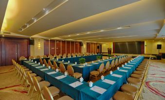 A spacious room with long tables and blue chairs is available for events or functions at the hotel at UChoice Hotel