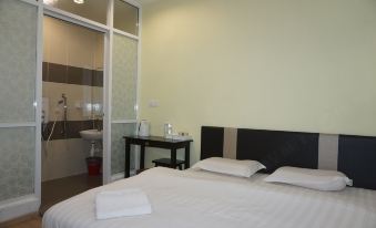 a clean and well - organized hotel room with a double bed , a bathroom , and a desk at Sun Inns Hotel Ayer Keroh