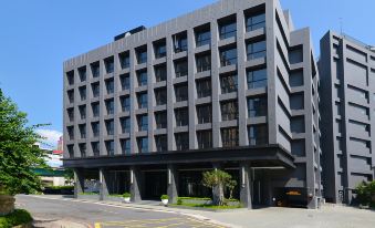 "a large black building with many windows , situated next to a street with a sign that says "" jp "" in the middle" at Platinum Hotel