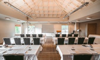 a large conference room with multiple tables and chairs , all set up for an event at Scenic Hotel Bay of Islands