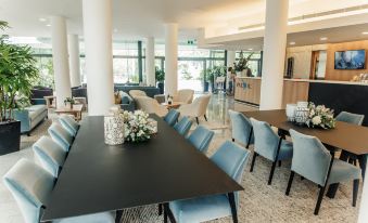 a large dining room with blue chairs and a long table surrounded by couches , chairs , and a bar at Mercure Brisbane Spring Hill