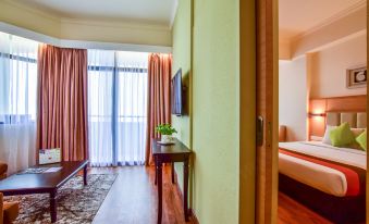 The bedroom features large windows and sliding doors that connect to the living area and lead to another room at Hotel Sentral Seaview @ ​Beachfront