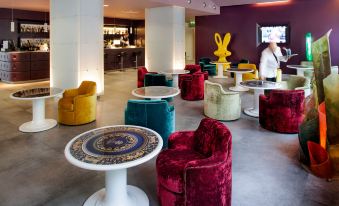 a modern lounge area with colorful chairs and tables , creating a vibrant and inviting atmosphere at Hotel Da Vinci