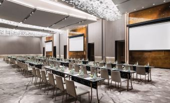A spacious room is arranged with long tables and chairs for an event or conference at Cordis Shanghai Hongqiao