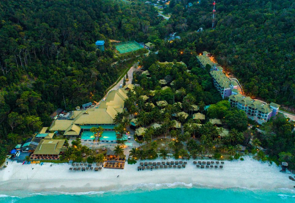 aerial view of a tropical resort with multiple buildings , pools , and beach on the coast at The Taaras Beach & Spa Resort