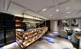 The bar is situated in a room that has an open concept and is connected to a private dining area at Howard Johnson Huaihai Hotel Shanghai