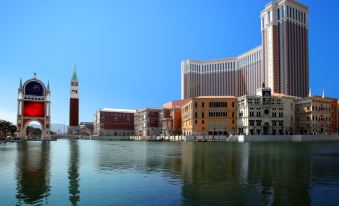 There is a view of buildings and hotels from the water, with boats on it at The Venetian Macao