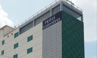 a large building with a hotel name on the side and a balcony on the bottom at Hotel Valentino