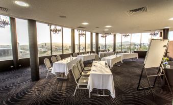 a conference room with multiple tables and chairs , all set up for a meeting or event at Mercure Brisbane Spring Hill