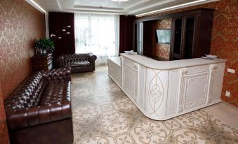 a large , modern office with a reception area featuring a white marble counter and brown leather couches at Vernisage