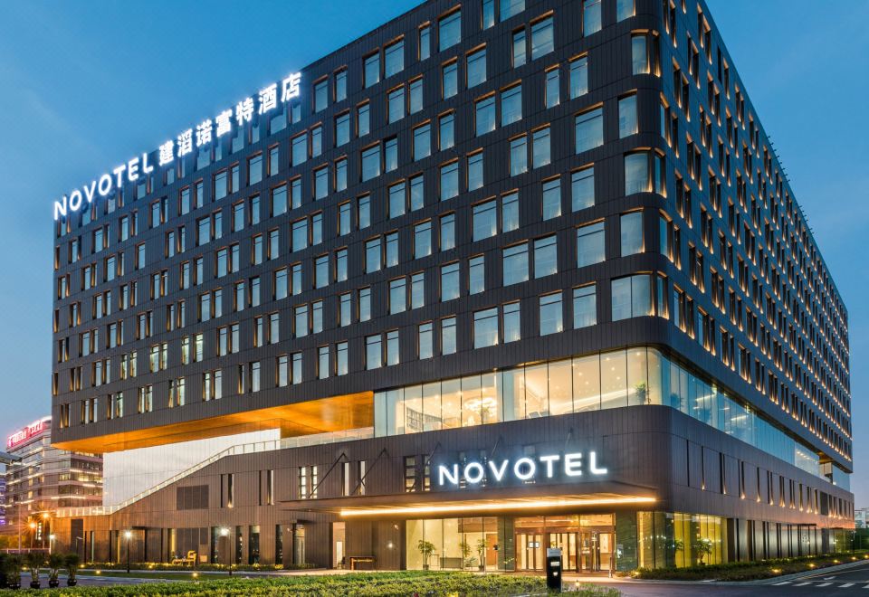 The hotel features a large glass and steel building in the background, providing a striking front view at night at Novotel Shanghai Hongqiao