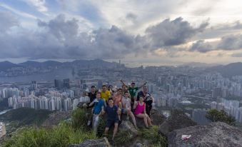 A group photo was taken from a high vantage point, with people standing in front and mountains in the background on both sides at Check Inn HK