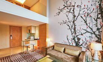 elegant and spacious living area, featuring large windows, a comfortable couch, and a central table at Dorsett Shanghai