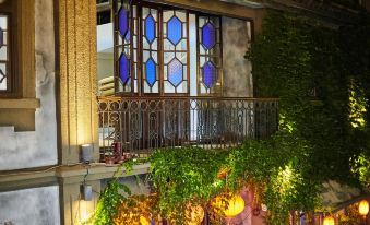 At night, an ornate building with windows and balconies lines the wall at Yiman Hotel (Suzhou Pingjiang Road Scenic Area)