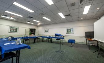 a conference room set up for a meeting , with tables and chairs arranged in a semicircle at Twin Towers Inn