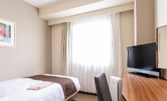 a hotel room with a bed , curtains , and a desk , giving a cozy and comfortable atmosphere at Kichijoji Tokyu Rei Hotel