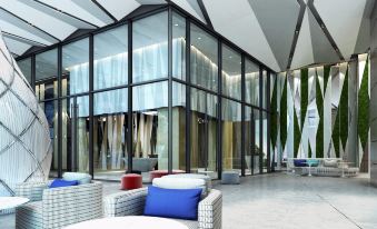 a modern lobby with white walls , large windows , and blue cushions , as well as a seating area at Hotel Cham Cham - Taipei