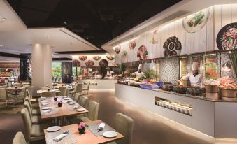 The dining room features an open concept design with tables and chairs along the wall at Shangri-La Shenzhen Hotel