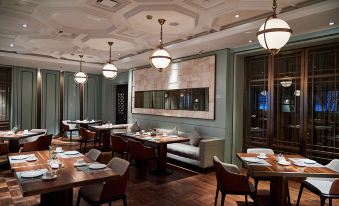 The restaurant features a central area with tables and chairs, as well as an open concept dining room at Metropolo Jinjiang Hotels Classiq (Shanghai Qingnianhui People's Square)