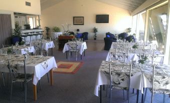 a dining room with tables and chairs arranged for a large group of people to enjoy a meal together at Lindy Lodge Motel