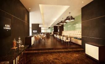 a modern , well - lit restaurant with wooden flooring and a large dining area filled with tables and chairs at DoubleTree by Hilton Melaka