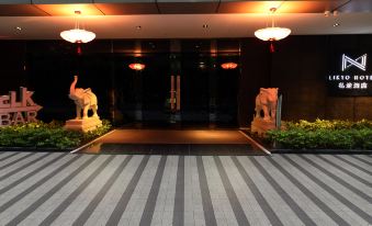 The entrance to a building features large wooden doors and tiled floors at Likto Hotel (Guangzhou Taojin Metro Station)