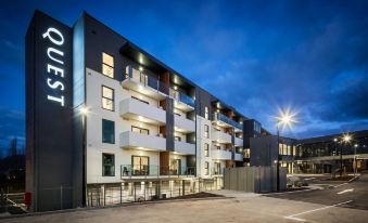 a modern apartment building with a white exterior and black exterior , lit up at night at Quest Wodonga