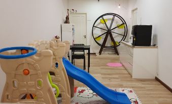 a playroom with a slide , toys , and a large wheel , giving it an open and playful atmosphere at G Residence