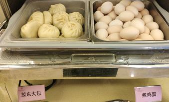 a display case with two trays of food , one filled with dumplings and the other with eggs at Sunshine Hotel