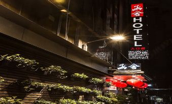 "a nighttime view of a hotel building with red signage and a sign for the "" felix hotel ""." at Han She Business Hotel