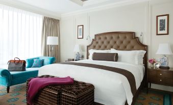 There is a large bed with an upholstered headboard and a side table in the middle room at The Langham, Shenzhen