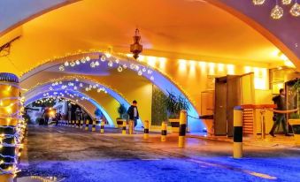a tunnel - like structure with blue lights and snowflakes , as well as people walking through the tunnel at Sheraton Hotel