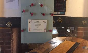 a restaurant counter with a certificate on it , along with a vase of flowers and a wine glass at The Willow House