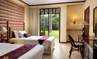 a hotel room with two beds , a window , and a desk , all decorated in a modern style at Holiday Resort Lombok