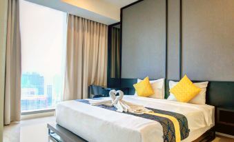One end of the area is a bedroom with two beds and a large window that overlooks the city at Tropicana the Residences KLCC by Luxury Suites