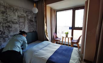 bedroom with a separate balcony that offers a city view through its large windows at Super 8 Hotel Premier (Beijing Workers' Stadium Sanlitun Chunxiu Road)