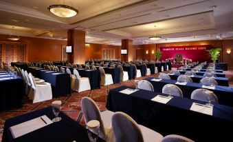 A spacious room is arranged with tables and chairs for hosting events at a hotel or conference at Harbour Plaza Resort City