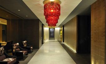 There is a long hallway with an illuminated chandelier hanging from the ceiling and other lighting fixtures at Jinjiang Inn Select (Shanghai Nanjing Road Pedestrian Street)