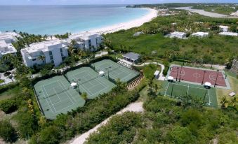 an aerial view of a beach resort with multiple tennis courts , a golf course , and a body of water at Four Seasons Resort and Residence Anguilla