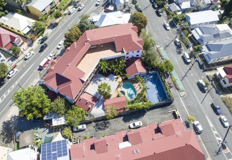 an aerial view of a residential area with multiple houses , a swimming pool , and trees at Brisbane Backpackers Resort
