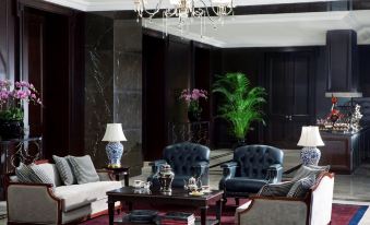 There is a living room with two chairs and an armchair positioned in front of a coffee table at The Langham, Shenzhen
